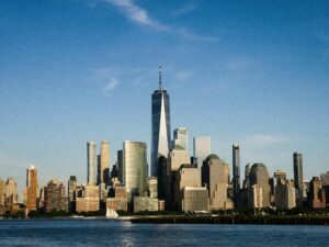 Stunning view of New York City skyline with One World Trade Center shining under a clear blue sky.