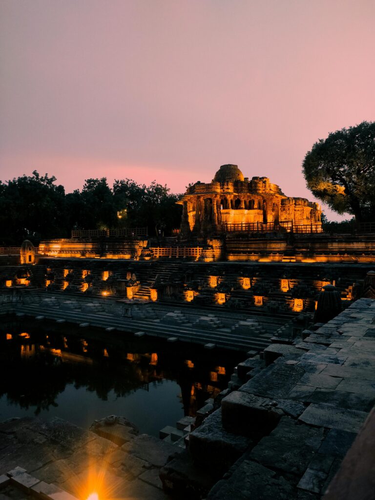 Dusk shot of the ancient Modhera Sun Temple in Gujarat, India, beautifully lit against a serene twilight sky.